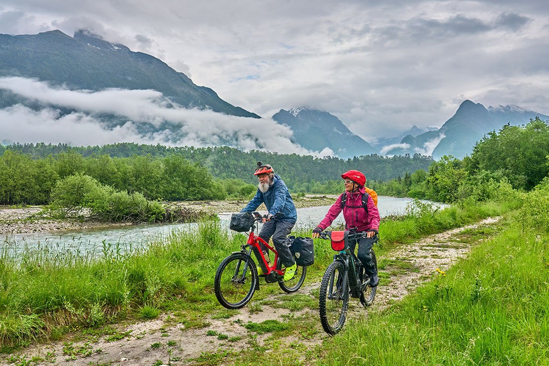Older people bicycling in scenic nature. 